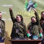 Four Israeli hostages, (L-R) Naama Levy, Liri Albag, Daniella Gilboa and Karina Ariev, wave on a stage before Hamas fighters hand them over to a team from the Red Cross in Gaza City on January 25, 2025. Hamas militants handed over four Israeli women hostages to the Red Cross in a January 25 swap after parading them on a stage at a square in Gaza, an AFP journalist reported. (Photo by Omar AL-QATTAA / AFP) (Photo by OMAR AL-QATTAA/AFP via Getty Images)