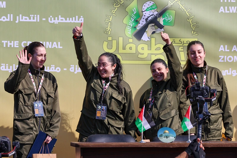 Four Israeli hostages, (L-R) Naama Levy, Liri Albag, Daniella Gilboa and Karina Ariev, wave on a stage before Hamas fighters hand them over to a team from the Red Cross in Gaza City on January 25, 2025. Hamas militants handed over four Israeli women hostages to the Red Cross in a January 25 swap after parading them on a stage at a square in Gaza, an AFP journalist reported. (Photo by Omar AL-QATTAA / AFP) (Photo by OMAR AL-QATTAA/AFP via Getty Images)