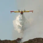 GLENDALE, CA - SEPTEMBER 9: A CL-215 "Super Scooper" air tanker drops a white cloud of water instead of the usual red fire retardant used by other air bombers at a wildfire September 9, 2002 in Glendale, California. The "Super Scooper," which scoops up water as it flies across a lake surface, is popular among politicians but some fire bosses are not yet sold on the new aircraft as a cost-effective means of suppressing fire. Homes were threatened today but none were lost in the 800-plus acre wildfire burning in the Los Angeles suburbs of Glendale and Burbank. Containment of the fire is set at 20 percent. (Photo by David McNew/Getty Images)
