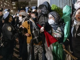 People hold their ground near a main gate at Columbia University in New York, Tuesday, April 30, 2024, as New York City police officers move to clear the area after a building was taken over by protesters earlier today. Colleges and universities have long been protected places for free expression without pressure or punishment. But protests over Israel