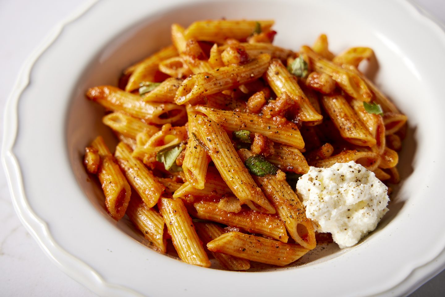 Salty pancetta and fermented pepper paste lend deep umami to this meaty pasta dish