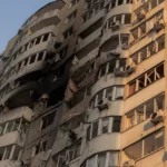 A man looks out from a burned apartment in a residential building damaged during a Russian air strike in Kyiv on June 6, 2025, amid the Russian invasion of Ukraine. Russia carried out a barrage of drone strikes across Ukraine overnight, killing at least four people and wounding 20 in the capital Kyiv, Ukrainian officials said on June 6. (Photo by Roman PILIPEY / AFP) (Photo by ROMAN PILIPEY/AFP via Getty Images)