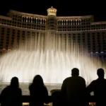 Tourists are silhouetted as they watch the Bellagio fountain show on the Las Vegas Strip October 12, 2005 in Las Vegas, Nevada. (Photo by Ethan Miller/Getty Images)